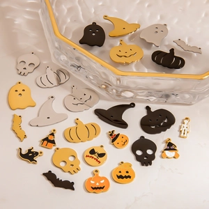 Flat lay of diverse Halloween charms including pumpkins, ghosts, and bats for DIY jewelry