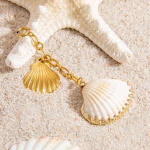 Starfish and shell pendant 18K gold stainless steel jewelry on white sand beach background