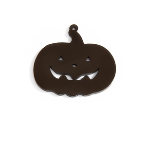 Macro view of black pumpkin charm with carved Jack-o'-lantern face for Halloween