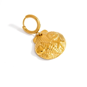 Detail of a gold stainless steel round pendant featuring embossed seashell and starfish motifs