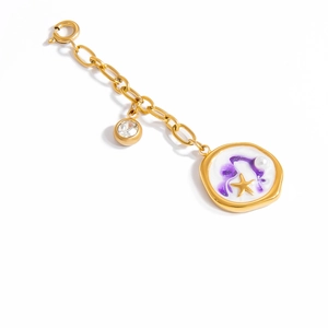 Macro shot of gold bikini charm with purple enamel pendant and star pearl details