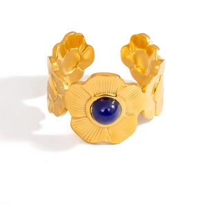Anello regolabile a fiore in oro 18K con gemma blu e petali con trama a rilievo