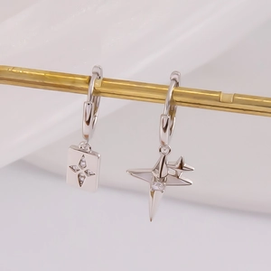 Gros plan détaillé de boucles d'oreilles en argent 925 avec plaque étoile et pendentif avion