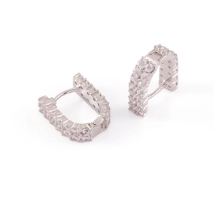Détail macro de boucles d'oreilles huggie en argent avec double rangée de zircons