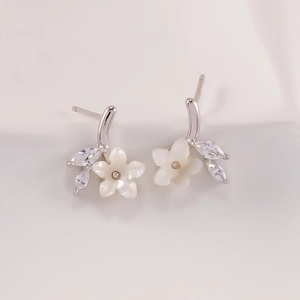 Nahaufnahme der S925 Silber Blumenohrstecker mit weißen Muschelblättern und Zirkonsteinen