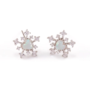 Makro-Detail von Schneeflocken-Ohrsteckern mit Opal-Herz und zirkonbesetzten Silberblüten