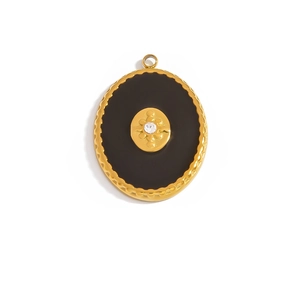 Detailed view of a gold oval pendant with black enamel surface and a central sparkling zircon