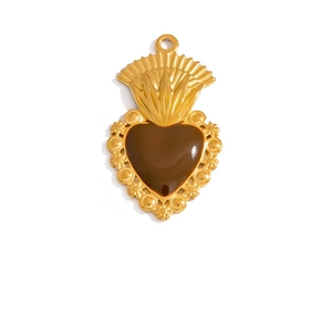 Detailed macro view of a vintage Sacred Heart pendant in gold plating with brown resin