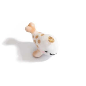 Pendentif baleine mignon avec taches brunes et anneau doré sur fond blanc