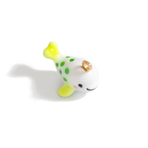 Gros plan détaillé d'un pendentif poisson en céramique avec points verts et anneau doré