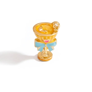 Macro shot of a golden trophy pendant featuring a blue 3D bow and hanging loop detail