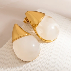 Macro detail of French style water-drop earrings with gold finish and resin inlays