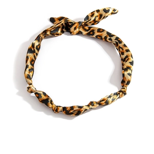 Dettaglio di fascia per capelli leopardata con trama satinata e nodo superiore