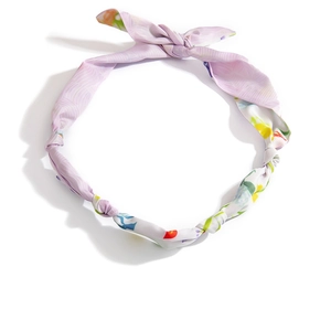 Dettaglio ravvicinato della fascia in raso lavanda con stampa floreale e fiocco elegante
