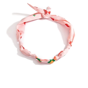Dettaglio della fascia rosa con stampa a fragole, nodo intrecciato e orecchie di coniglio