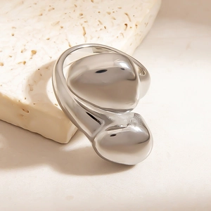 Polierter Edelstahl-Wickelring mit flüssigem Metalldesign auf einem Steinsockel