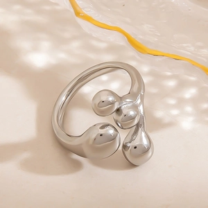 Macro detail of a silver irregular fluid ring featuring three polished droplet spheres