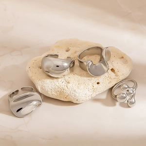 Irregular liquid metal geometric rings on stone display with high mirror finish
