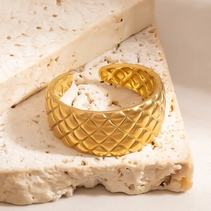 Minimalist gold open ring featuring a classic quilted texture on a wide metal band
