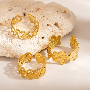 Three-piece set of golden stainless steel rings featuring heart and flower designs