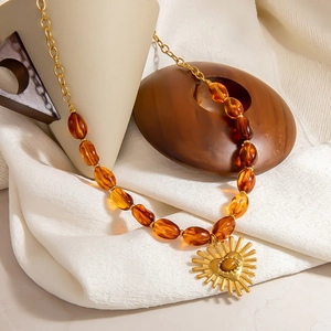 Retro resin bead necklace with golden heart pendant on elegant white silk and wooden props