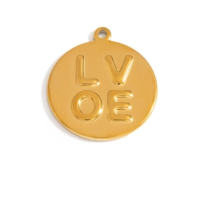 Macro shot of gold circular pendant with embossed LOVE text and polished mirror finish