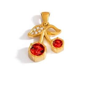 Detail of a gold cherry pendant with red crystal stones and diamond-set leaves