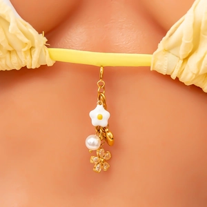 Detail eines 18K vergoldeten Bikini-Anhängers mit weißen Blumen, Perlen und Kristallen