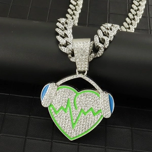 Detail of silver iced out Cuban chain with heart and headphone pendant for hip hop music lovers