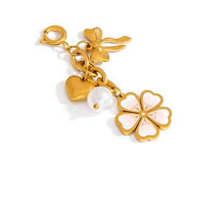 Detail eines goldenen Bikini-Anhängers mit Emaille-Blume, Herz und Perlenanhängern