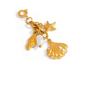 Goldener Ozean-Bikini-Anhänger mit Seestern, Muscheln und Perle auf weißem Grund