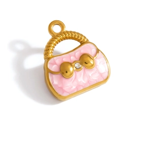 Macro view of gold-plated handbag charm with pink enamel marble texture and crystal bow