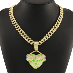 Detailed macro view of gold Cuban link chain with a green neon heart headphone pendant
