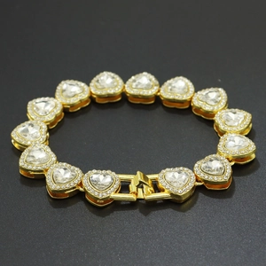 Détail macro du bracelet tennis doré avec maillons en cristal en forme de cœur et fermoir