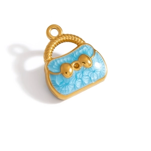 Macro shot of a golden metal handbag charm with light blue enamel and a bow detail