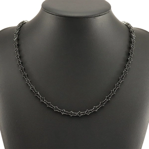 Iced out black tennis necklace with cross star links on a black bust display