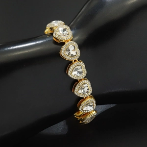 Vue détaillée du bracelet de tennis coeur doré avec cristaux sur un présentoir main