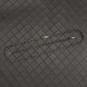 Macro shot of black plated cross flower tennis chain link with secure folding clasp closure