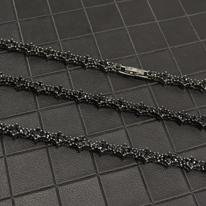 Detailed macro view of black tennis chain with prong-set crystals and metal clasp on leather