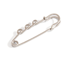 Detail shot of a silver metal safety pin brooch with a unique industrial spiral design