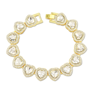 Détail d'un bracelet tennis doré orné de cristaux en forme de cœur et de diamants halo