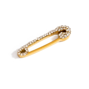Close-up of a gold-plated safety pin brooch with sparkling crystals on white background