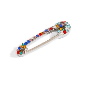 Detailed view of safety pin brooch featuring vibrant multi-colored inlaid rhinestones