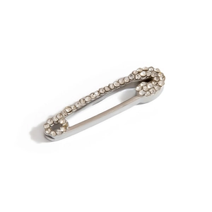 Macro shot of silver safety pin brooch with shimmering rhinestones and polished finish