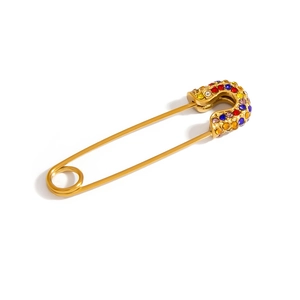 Detail view of a gold safety pin pendant featuring colorful rhinestones and premium finish