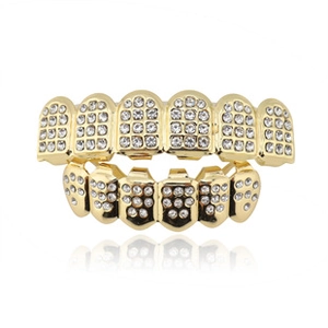 Detail of hip hop gold plated grillz set with pavé white rhinestones on white background