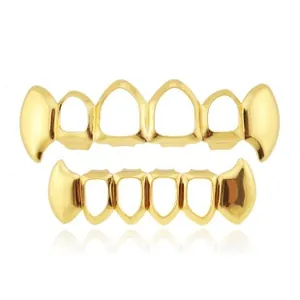Detail view of gold-plated hiphop grillz with hollow frames and fangs on white background