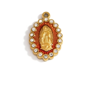 Macro detail of a golden Virgin Mary pendant with red enamel and sparkling rhinestones