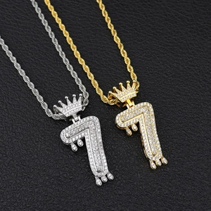 Close-up of gold and silver number 7 hip hop pendants with crowns and zircon stones