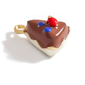 Detailed macro view of chocolate cake slice pendant with colorful enamel and gold ring